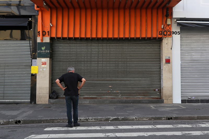 Homem parado em frente a lojas fechadas no centro de São Paulo depois que autoridades decretaram o fechamento do comércio em medida de precaução contra o coronavírus 20/03/2020 REUTERS/Amanda Perobelli