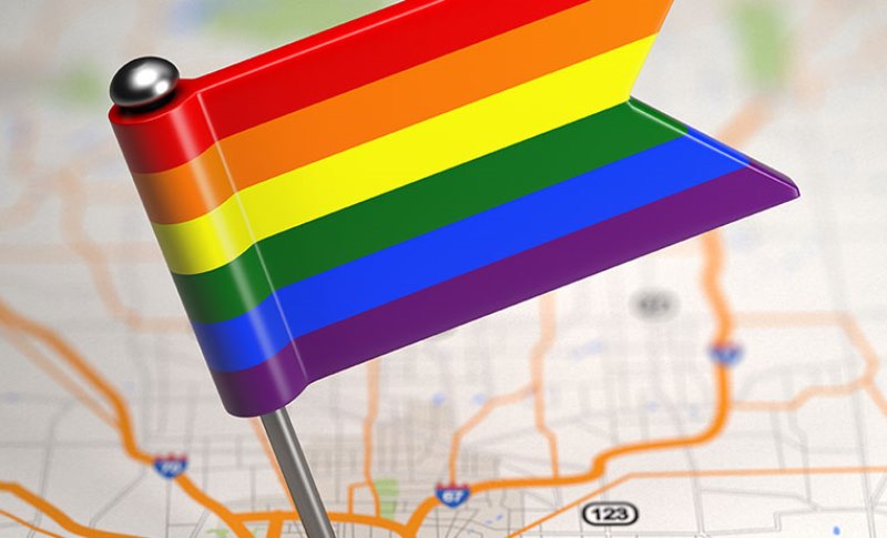 Gay Small Flag on a Map Background.