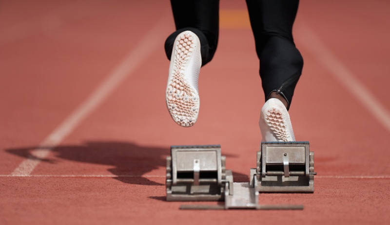 Back view of male feet on starting block ready for a sprint start