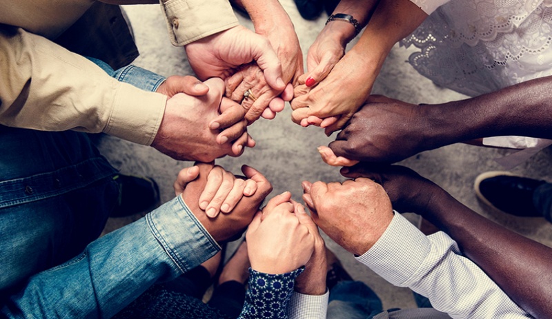 Group of diverse hands holding each other support together teamwork aerial view