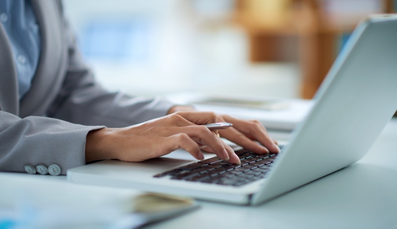 Hands of business lady working on laptop