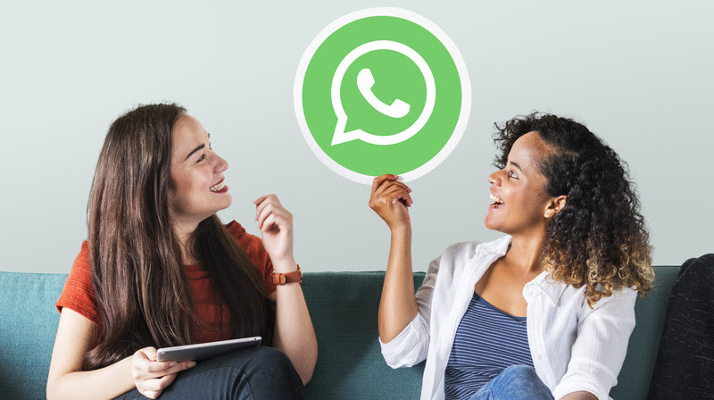 Young women showing a WhatsApp Messenger icon