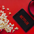 Calgary, Alberta. Canada. June 1 2020. An iPad with the Netflix logo on the screen on a red background with popcorn and headphones