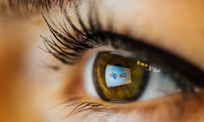 Bucharest, Romania – June 18,2016 : Blurry closeup of a wet brown eye with google’s logo reflected on it. Illustrative editorial taken from right side.