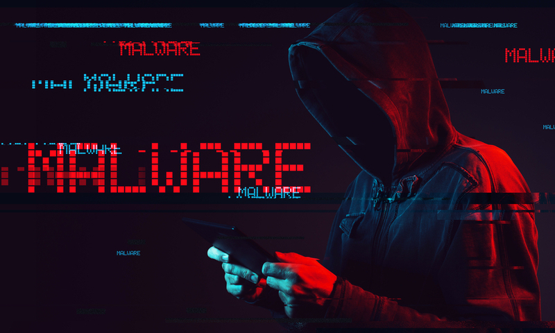 Malware concept with faceless hooded male person using tablet computer, low key red and blue lit image and digital glitch effect