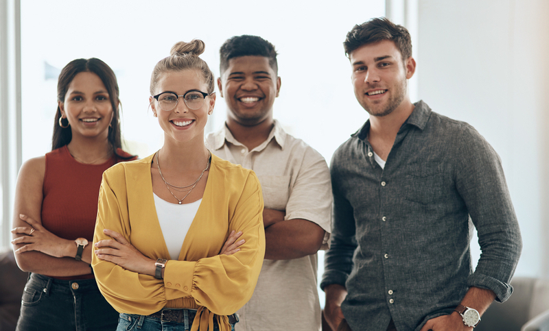 Thriving in a successful company. Portrait of a young businesswoman standing in an office with her colleagues in the background