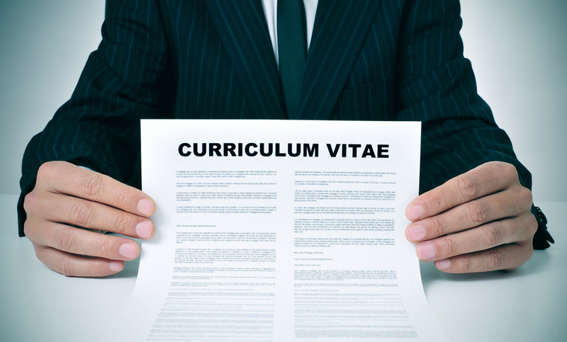 a man wearing a suit showing his curriculum vitae