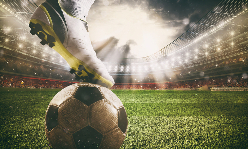 Football scene at night match with player ready to shoot the ball