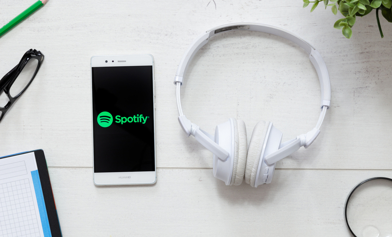 WROCLAW, POLAND – MARCH 29, 2018: Spotify is a music service that offers legal streaming music. Smartphone with Spotify logo on desk.