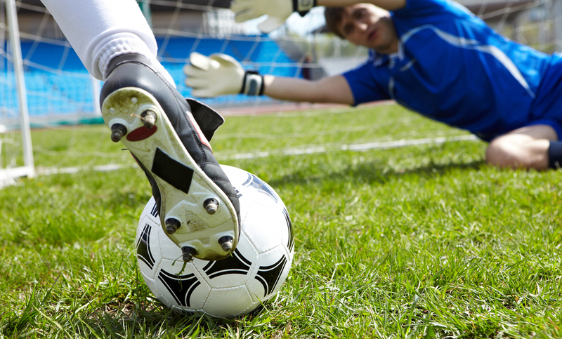 Horizontal image of soccer ball with foot of player kicking it