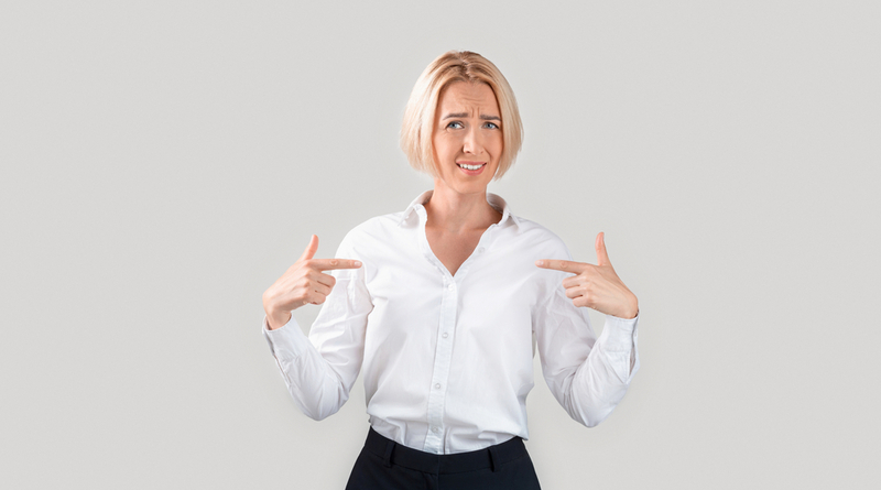 Ageism concept. Mature business lady pointing questioningly at herself, unhappy with nomination or dismissal on light background. Panorama