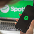 Kharkov, Ukraine – August 25, 2021: Woman using Spotify application and holding smartphone, close-up