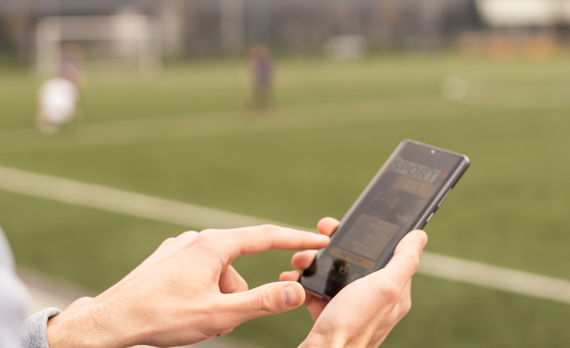 Man using online sports betting services on phone.