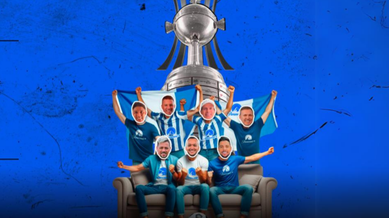 Jogadores de futebol usando a camiseta do Paramount + sentados no sofá. Ao fundo, a taça da Libertadores.