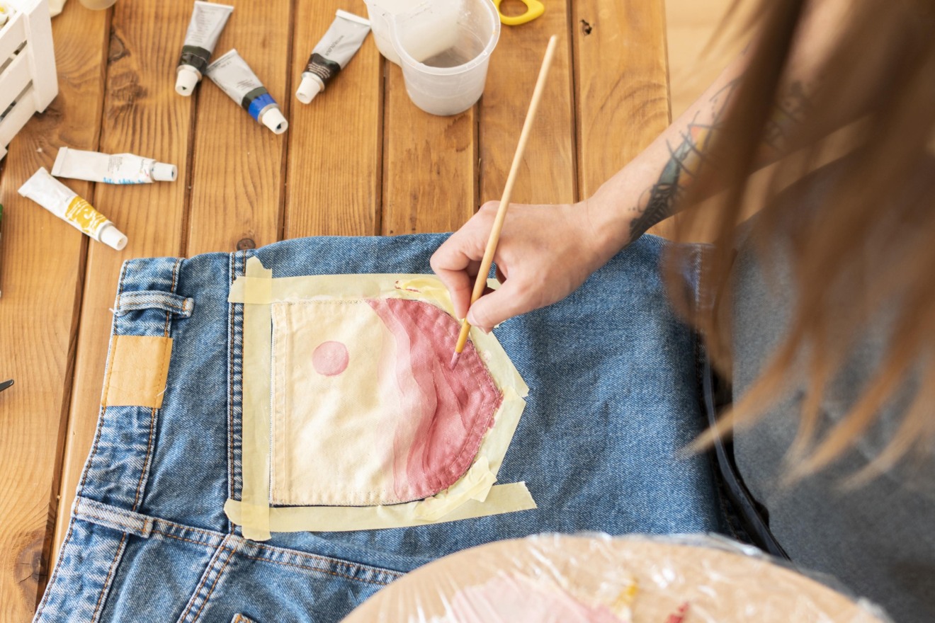 mulher customizando calça jeans