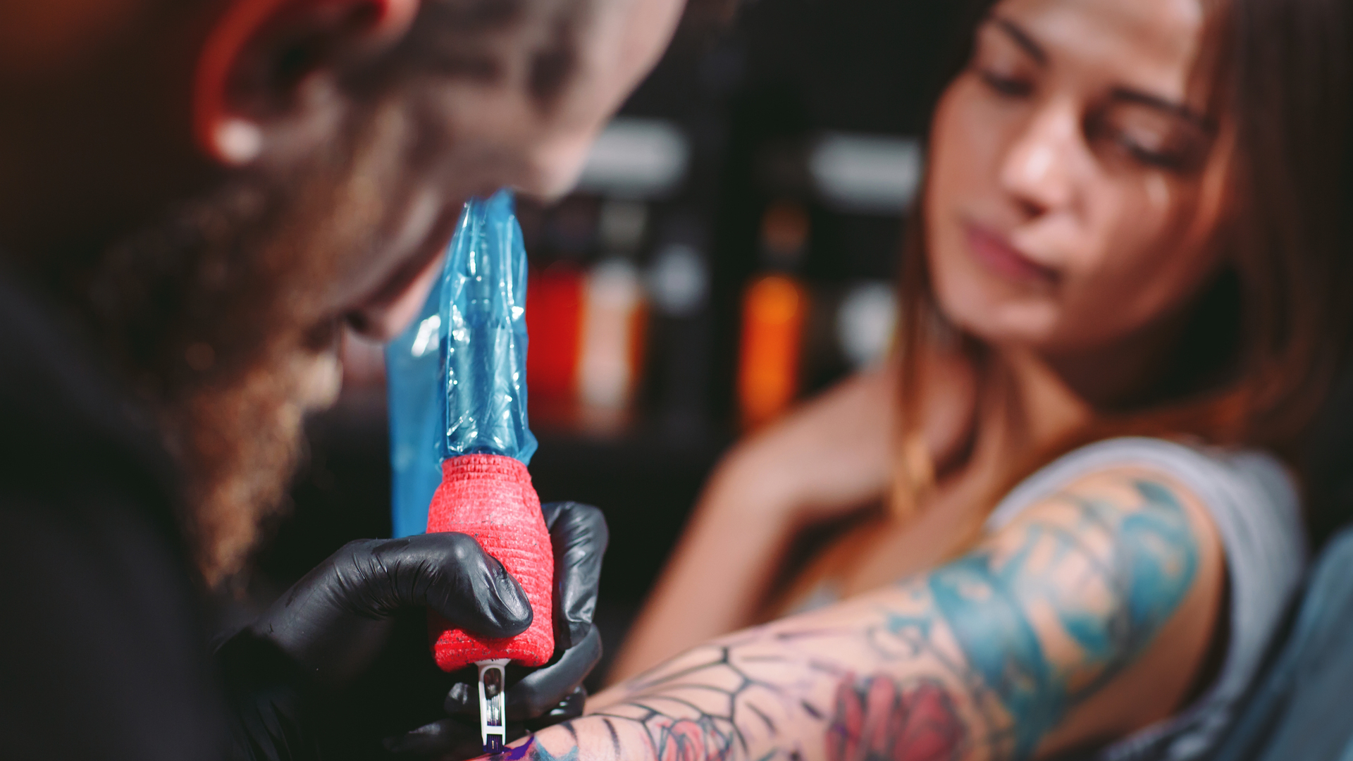 Professional tattoo artist makes a tattoo on a young girl's hand.