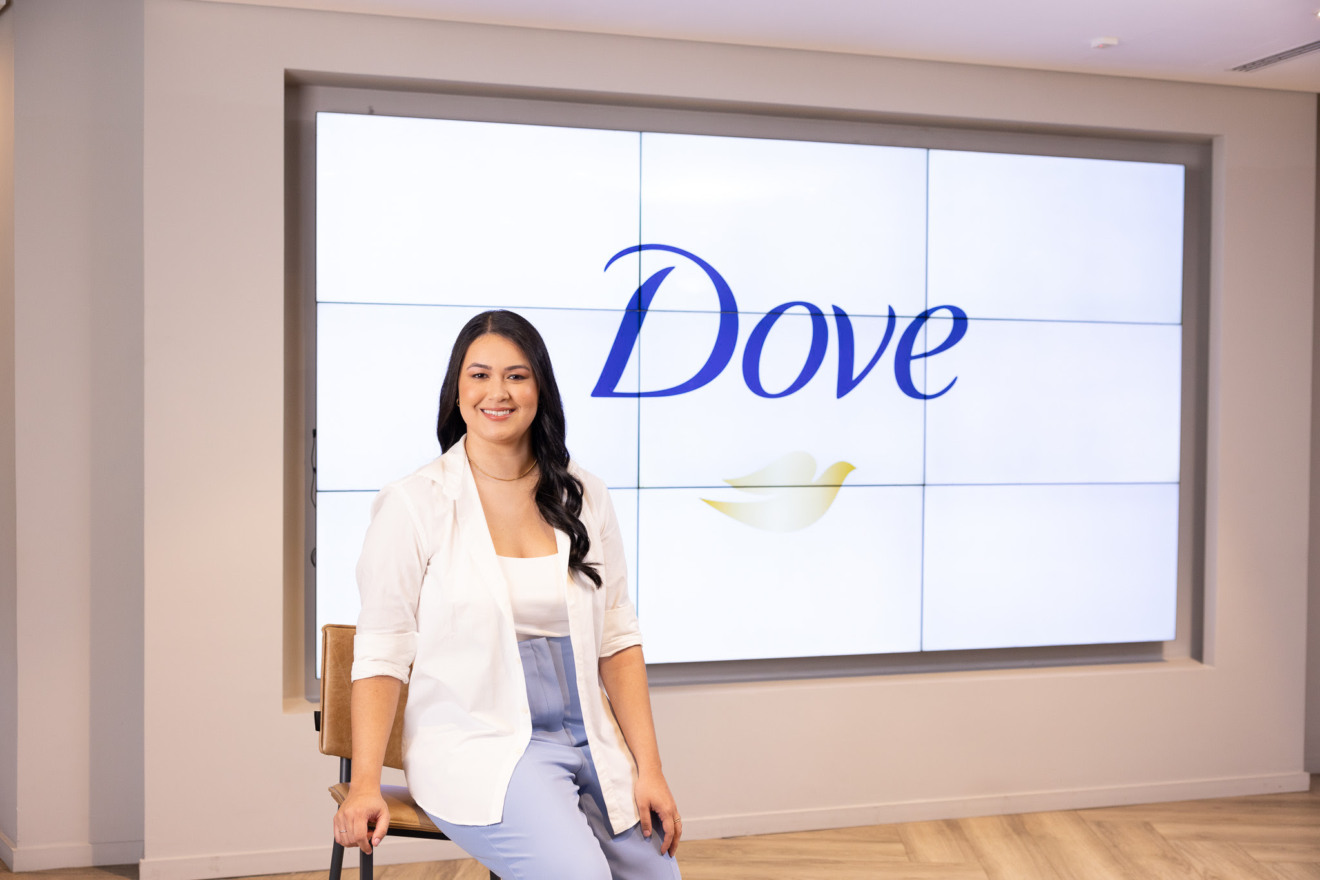 Heloisy Rodrigues posando com um painel Dove