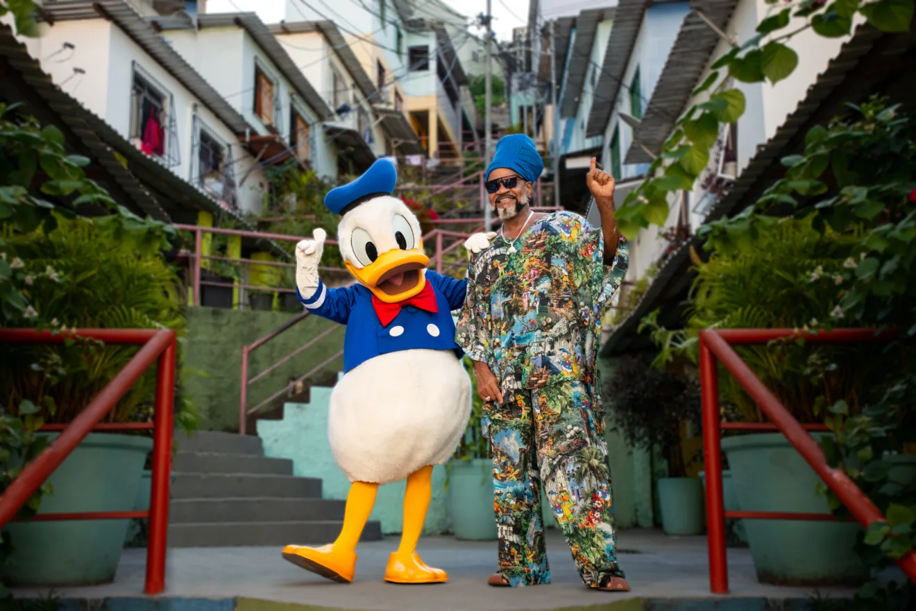 Imagem mostra o Pato Donald, da Disney, junto do cantor Carlinhos Brown