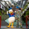 Imagem mostra o Pato Donald, da Disney, junto do cantor Carlinhos Brown