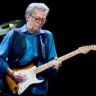 Foto do Eric Clapton no palco da turnê, tocando guitarra