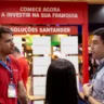 Pessoas conversam em frente ao espaço "Soluções Santander" na ABF Franchising