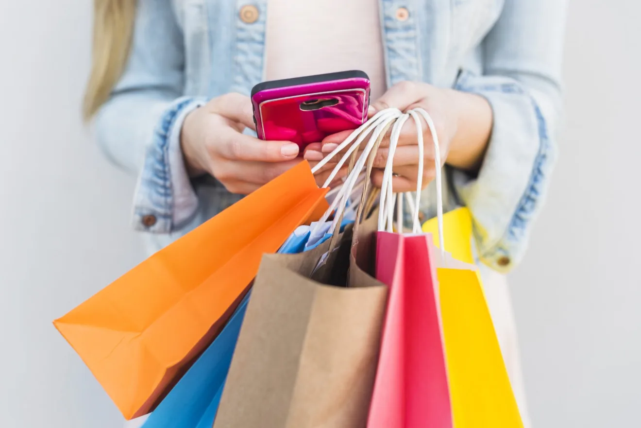 Imagem mostra uma mulher rodeada por sacolas, simbolizando Black Friday e cupons de desconto