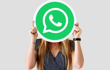 Imagem mostra uma mulher segurando a logomarca do WhatsApp