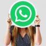 Imagem mostra uma mulher segurando a logomarca do WhatsApp