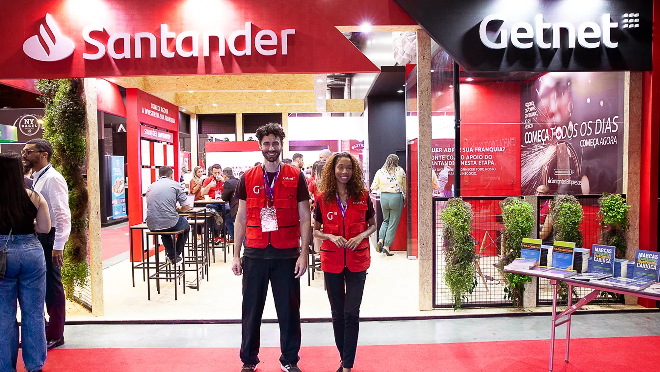 Dois promotores em frente ao estande de Santander e Getnet na ABF Franchising Expo