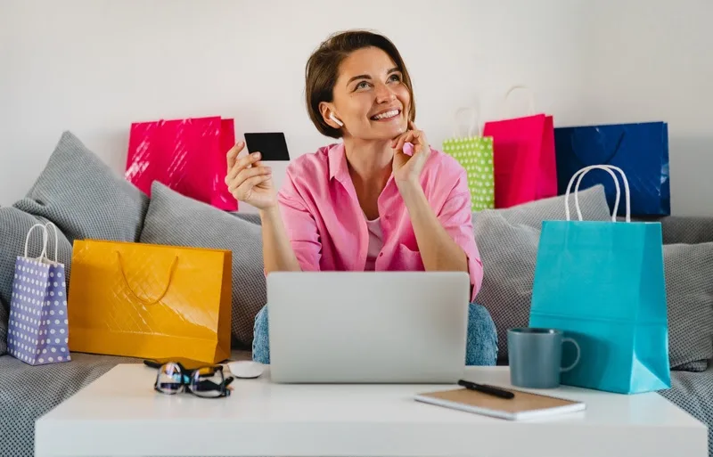 Imagem mostra uma mulher rodeada por sacolas, simbolizando Black Friday e cupons de desconto