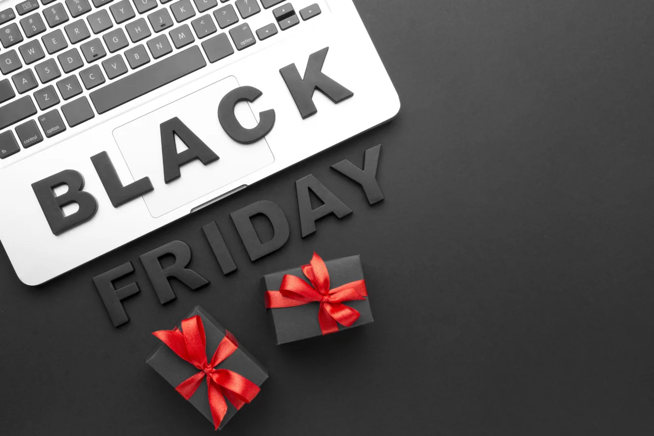 Imagem mostra as palavras "Black Friday" perto de um laço de presente e algumas caixas