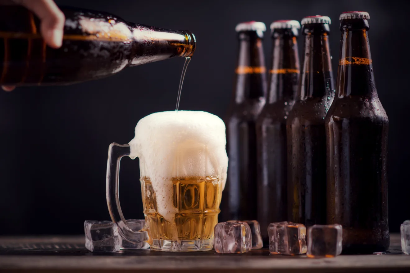 Imagem mostra um homem despejando cerveja em um copo