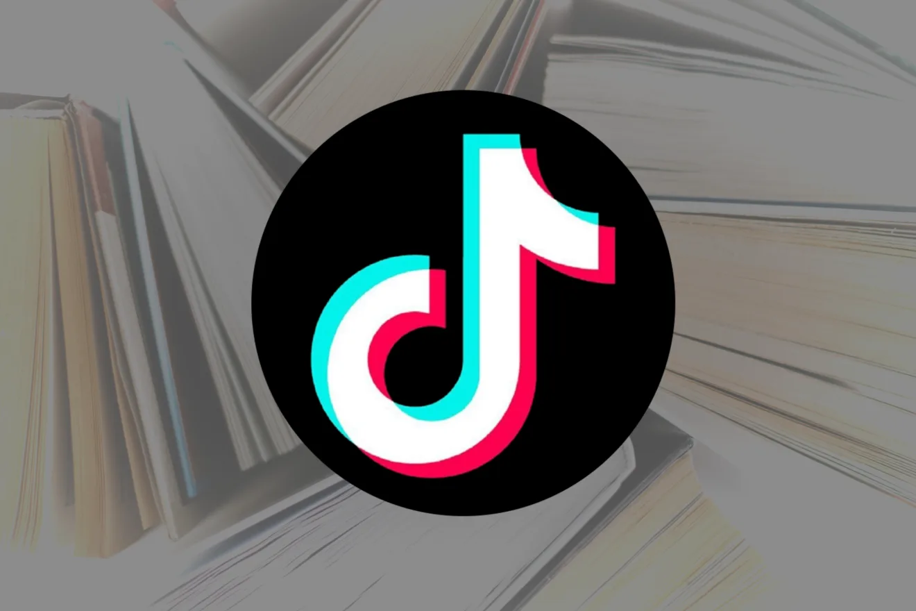 Imagem mostra logomarca do TikTok à frente de vários livros