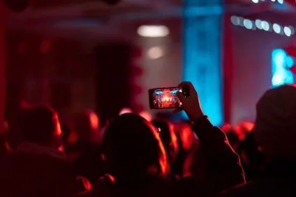 Imagem de pessoa segurando um celular que ilustra as tendências do mercado de eventos em 2025