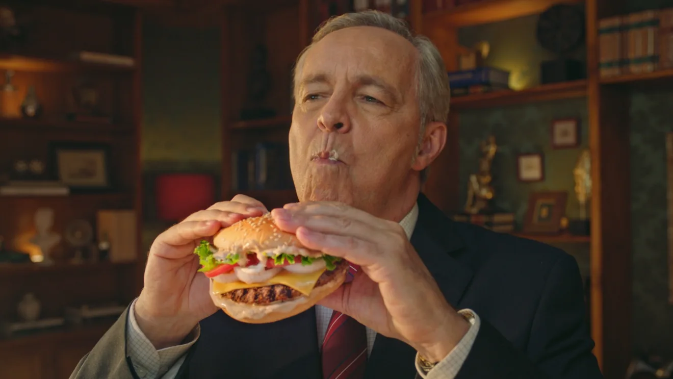 Imagem de um membro da Ordem dos Advogados do Brasil comendo o BK Taste, novo lanche do Burger King