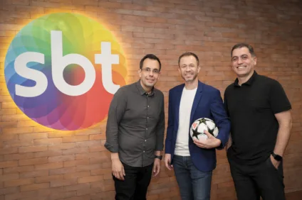 Imagem mostra Tiago Leifert, que será o novo narrador de Futebol do SBT, em meio ao time de diretores da emissora