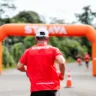 Imagem mostra um corredor indo em direção a um totem do Strava, portando uma camiseta da Olympikus