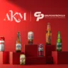 A imagem mostra garrafas e latas de cervejas do Grupo Petrópolis sobre um fundo vermelho, com a logo da marca e da agência AKM. Da esquerda à direita estão: Itaipava, Black Princess, Crystal Beer, Petra, TNT (energético), Cacilds e Cabaré.