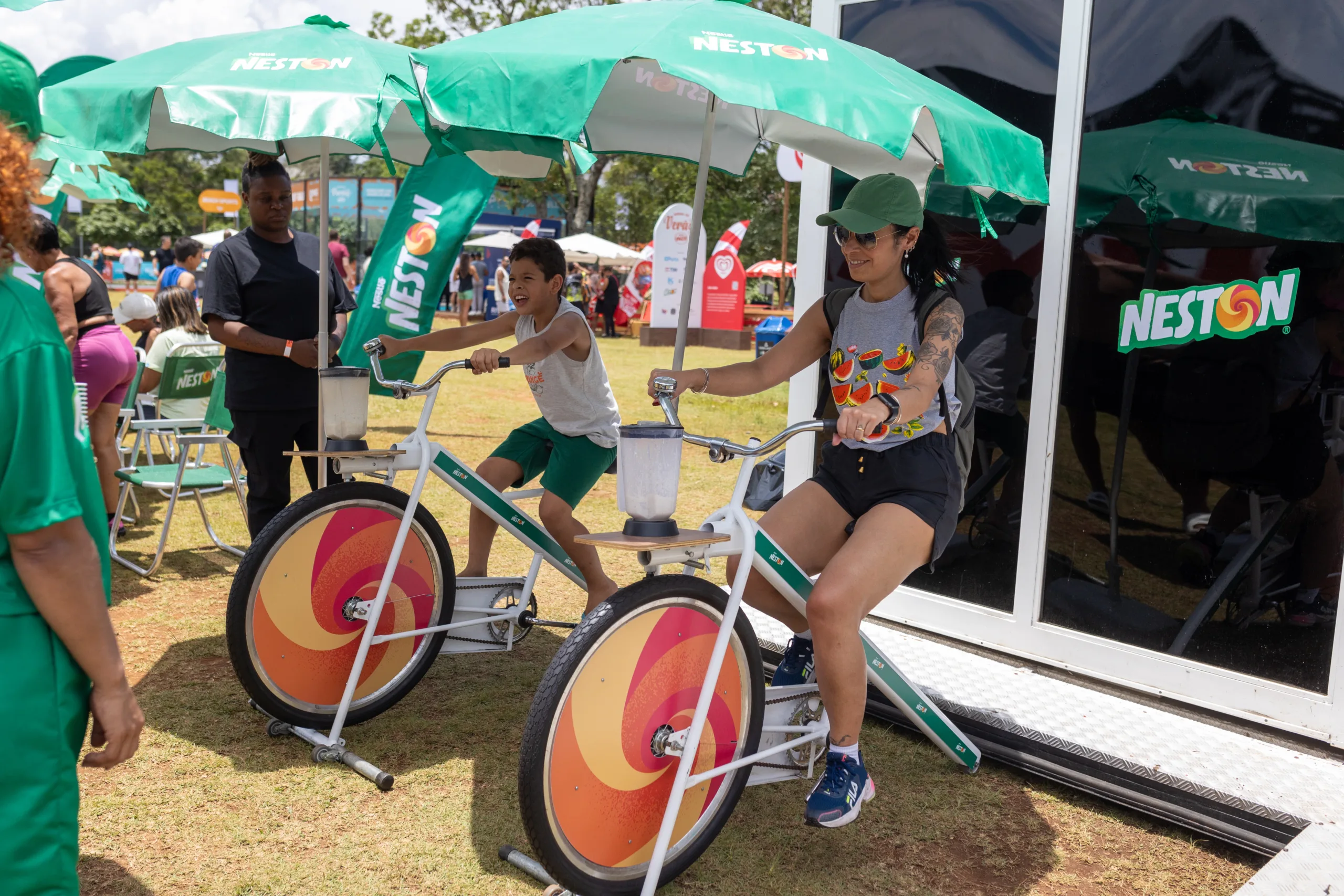 Pessoas pedalam em bicicletas na ativação da Neston