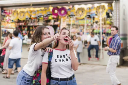 Imagem mostra duas amigas se divertindo em um parque, simbolizando eventos de marketing