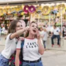 Imagem mostra duas amigas se divertindo em um parque, simbolizando eventos de marketing