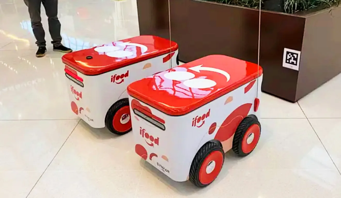 Imagem de dois dos robôs entregadores do iFood, criados pela Synkar