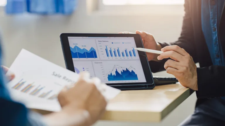 A imagem mostra uma pessoa apresentando gráficos de resultados num tablet
