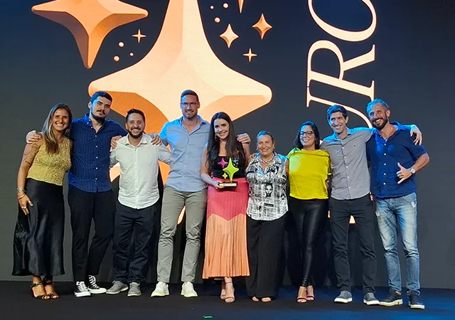 Equipe da R8 Live no palco do Bex Awards com os três troféus conquistados