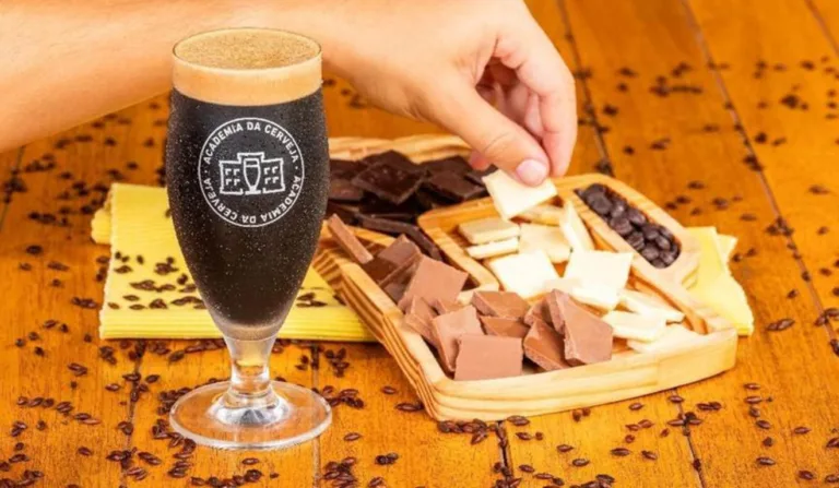 Imagem mostra uma cerveja da Ambev ao lado de uma bandeja de chocolates da Cacau Show