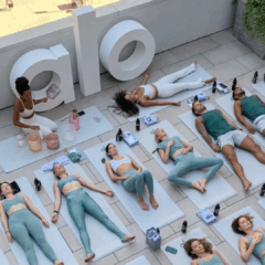 Pessoas praticando yoga em um terraço em um evento de wellness da Alo