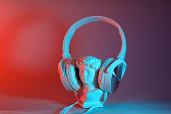 Imagem mostra uma pequena estátua de dorso masculino utilizando headphones