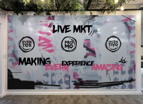 Parede estilizada da nova sede da Eventesse traz palavras como making experience, promo, incentivo, eventos e live mkt