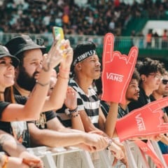 Pessoas na grade do I Wanna Be Tour com mãos de EVA da Vans