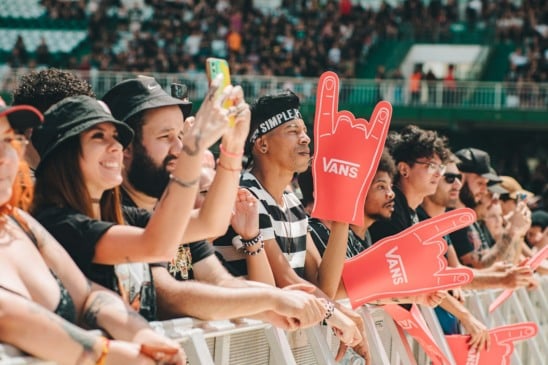 Pessoas na grade do I Wanna Be Tour com mãos de EVA da Vans
